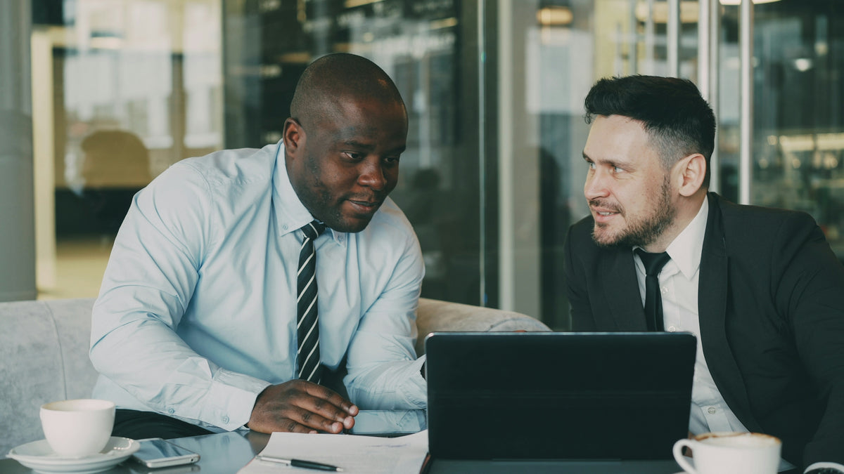 Two businessmen discussing documents at a table